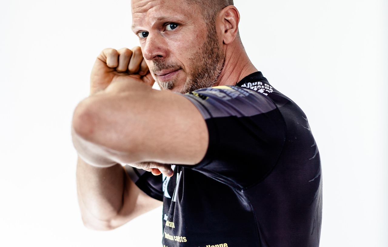 Luchador de MMA con rashguard y pantalón de entrenamiento sobre el tatami del gimnasio